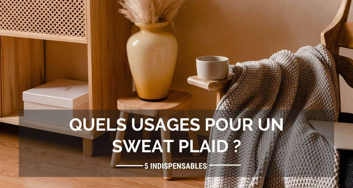Un plaid posé sur un canapé illustrant les multiples usages d'un sweat plaid